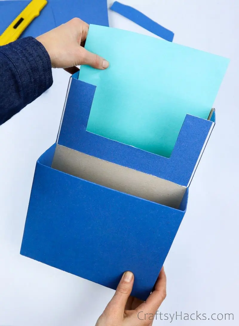 adding teal paper to inside of box